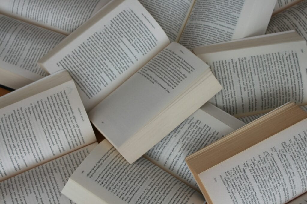 A collection of open books showing pages of text.